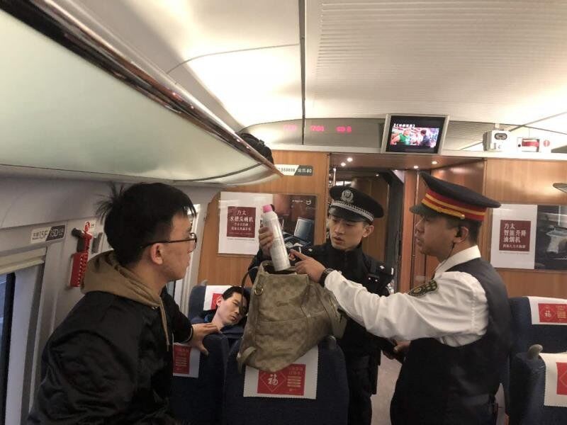 G196列車長鄭敏和乘警長在濰坊開車后對全列車的旅客行李進行危險品物品檢查。